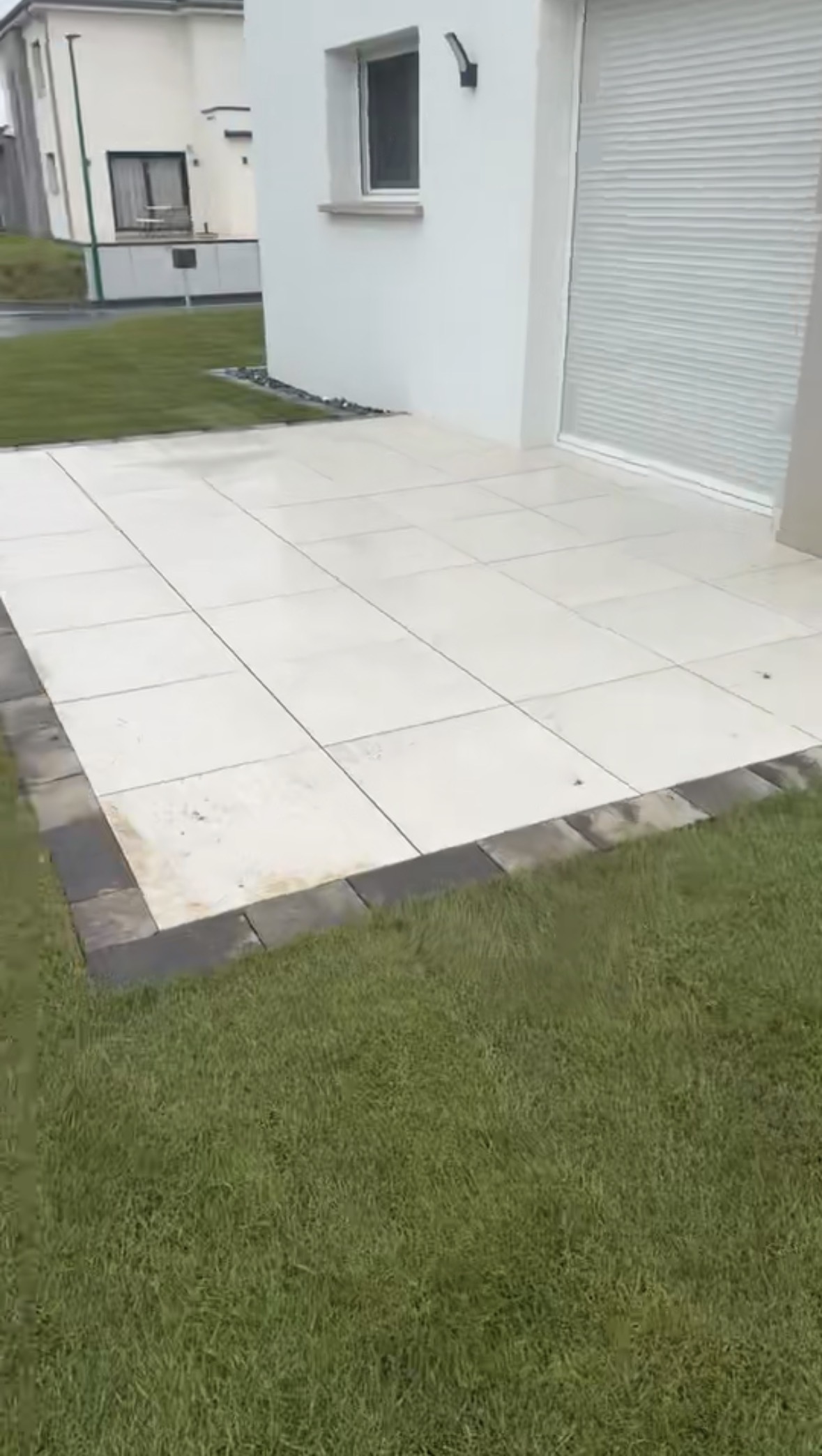 Terrasse dalles blanches avec bordure pavés devant garage